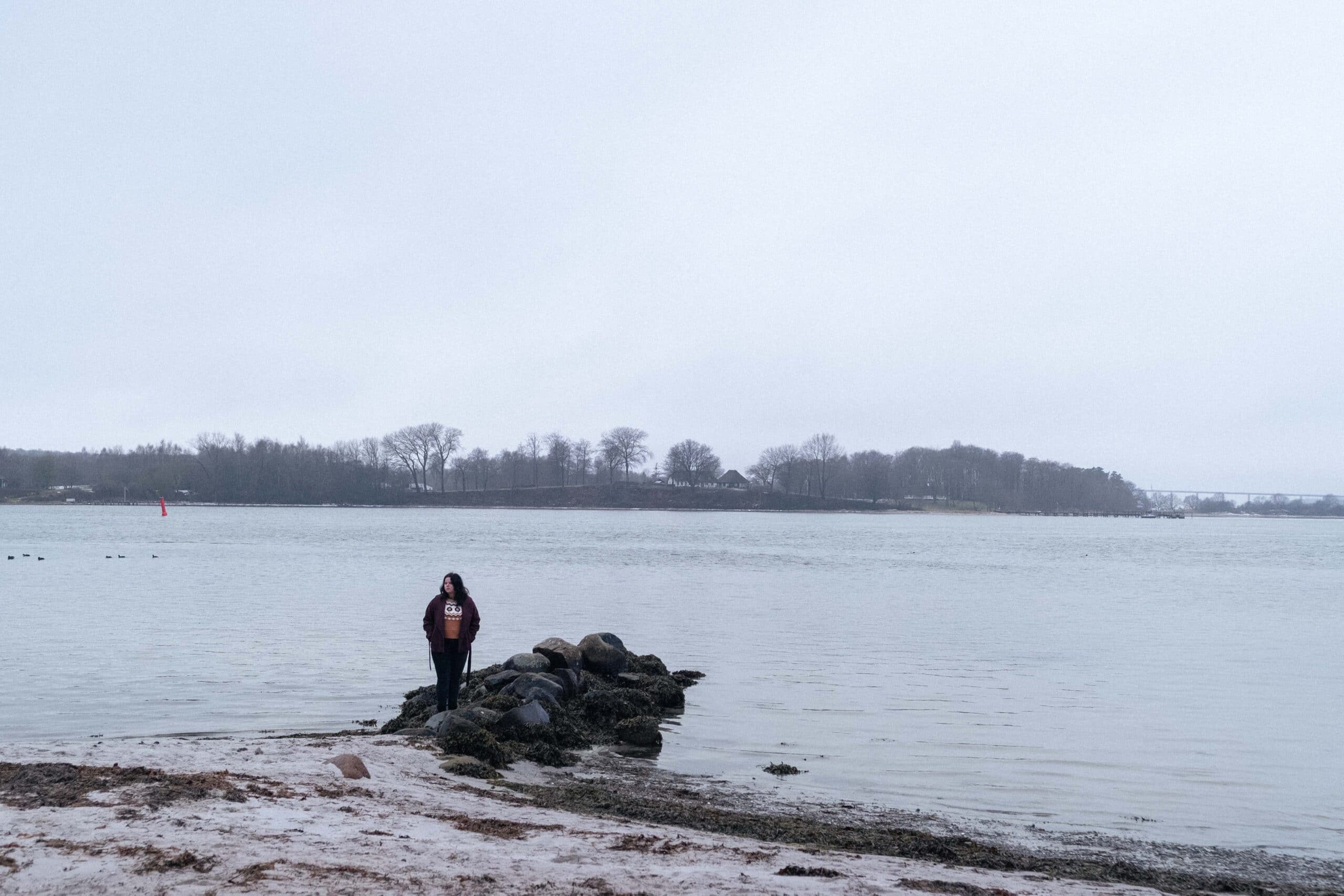 Victoria står på en strand.