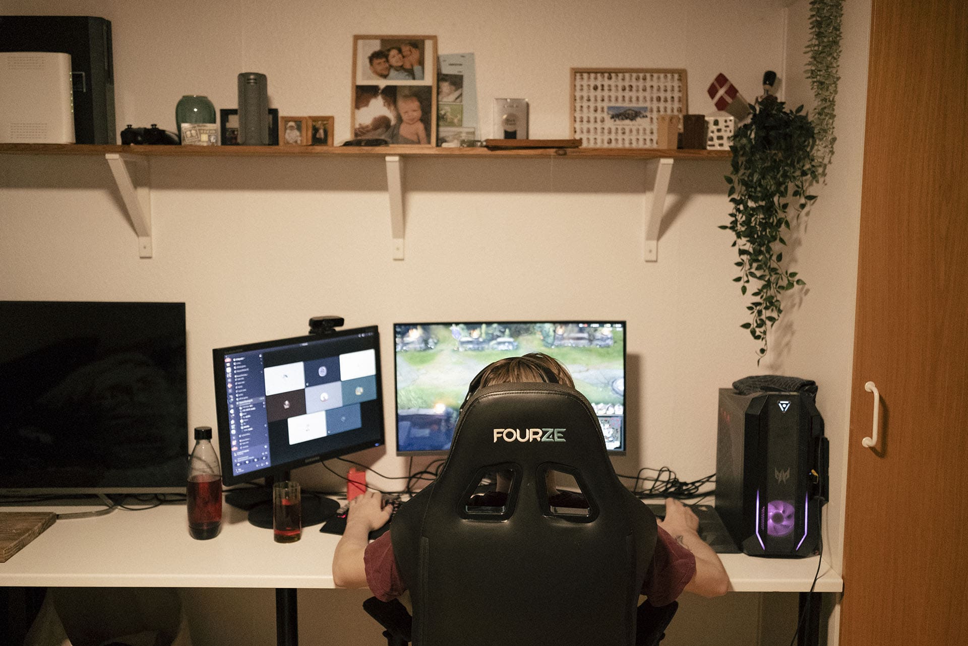 Sebastian sidder i en gaminstol foran et skrivebord med to skærme.