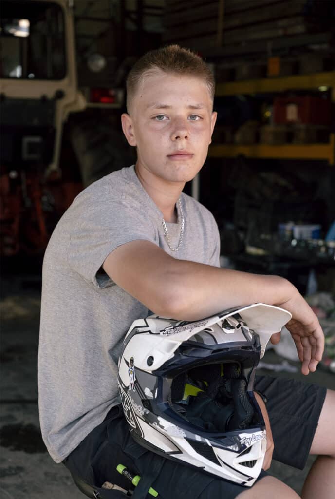 Portræt af Noah, der sidder i et værksted med armen hvilende på en motocrosshjelm.